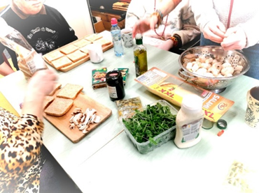 Mieszkańcy_wraz_gośćmi_z_Ostoi_przygotowują_tosty.png