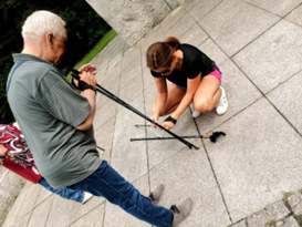 Zdjęcie_nr_11_przedstawia_instruktora_nordic_walking_poprawiającego_kije_Seniorowi.png