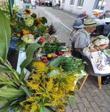 Zdjęcie_nr_13_przedstawia_Klientów_DDP_w_trakcie_uroczystości_dożynkowych_oraz_stół_z_darami_natury.png
