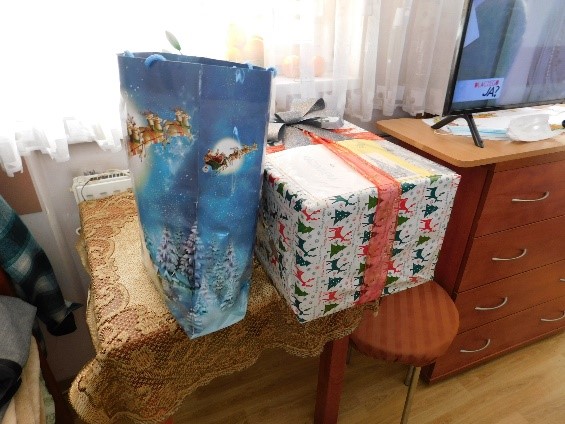 Zdjęcie. Widzimy tutaj paczki z prezentami leżące na stoliku.