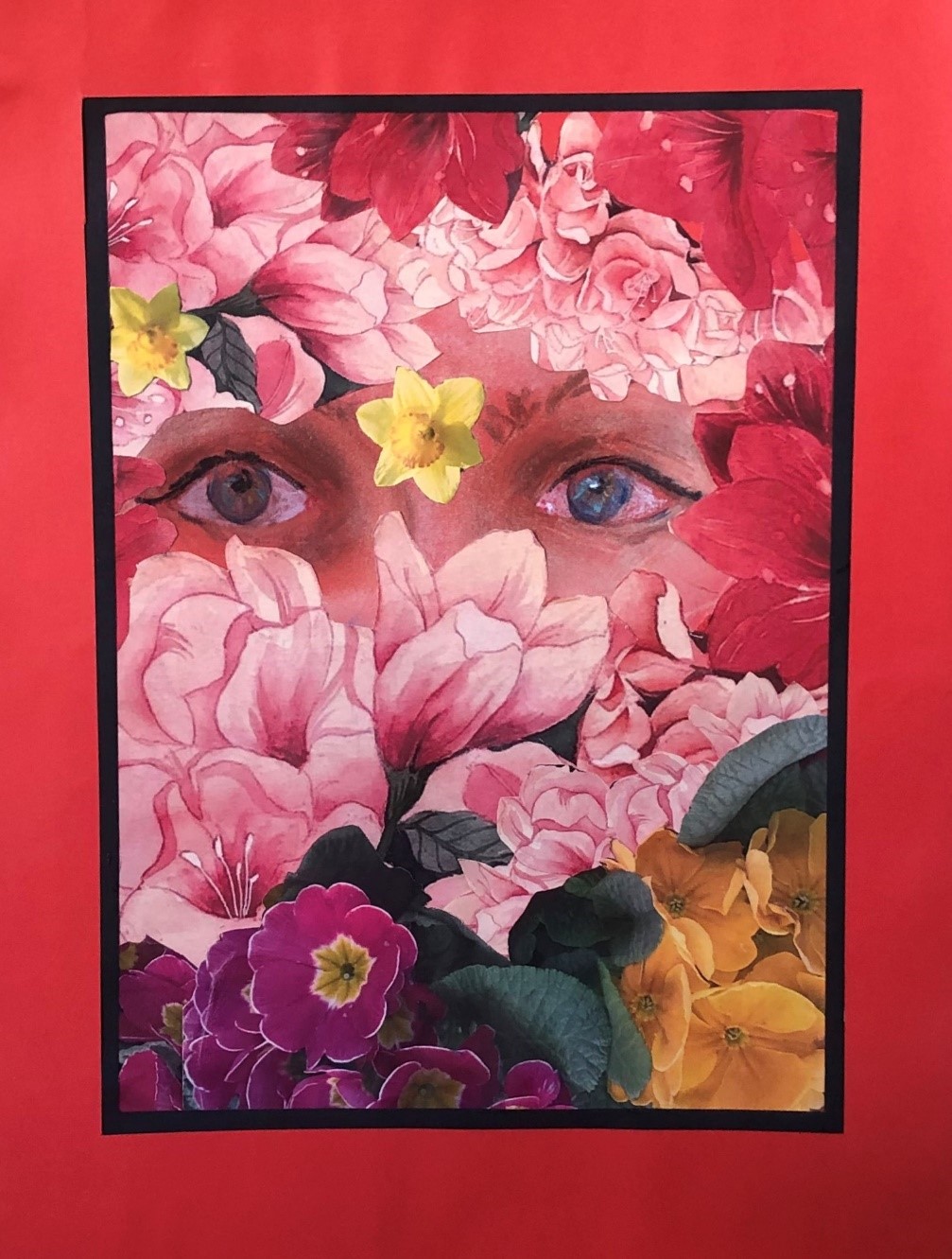 Fotografia 1 przedstawia nagrodzoną pracę autorstwa Pana Jerzego – Klienta DDP nr 1. Na zdjęciu widoczny obraz ukazujący niebieskie oczy pośród różowych, czerwonych, fioletowych i żółtych kwiatów. Obraz w czerwonej ramie