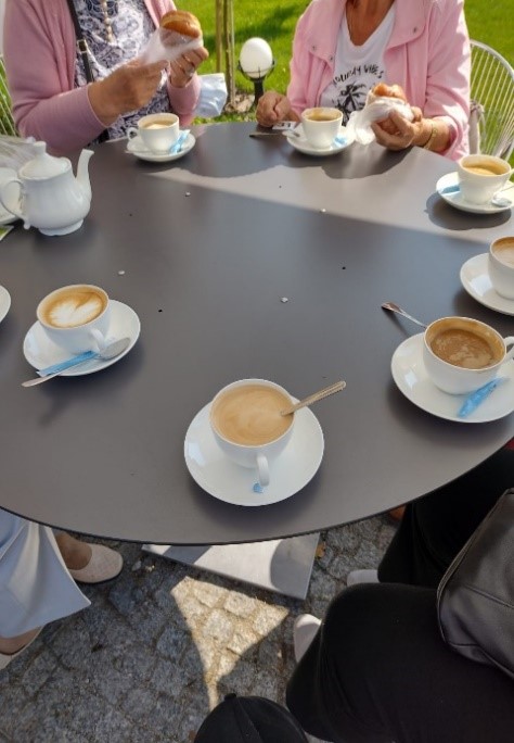 Kawiarnia na Ostrowie Tumskim. Klientki DDP siedzą przy stoliku, na którym stoją filiżanki z kawą i herbatą